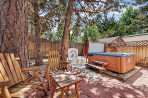 A backyard with a hot tub, wooden deck, and outdoor seating. - Montana Cabin #1938 (Big Bear City)