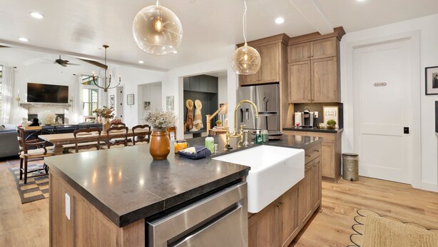 A modern kitchen with a central island, stainless steel appliances, wooden cabinets, and pendant lighting. - Pine Meadow Village Castle #2301 (Big Bear Lake)