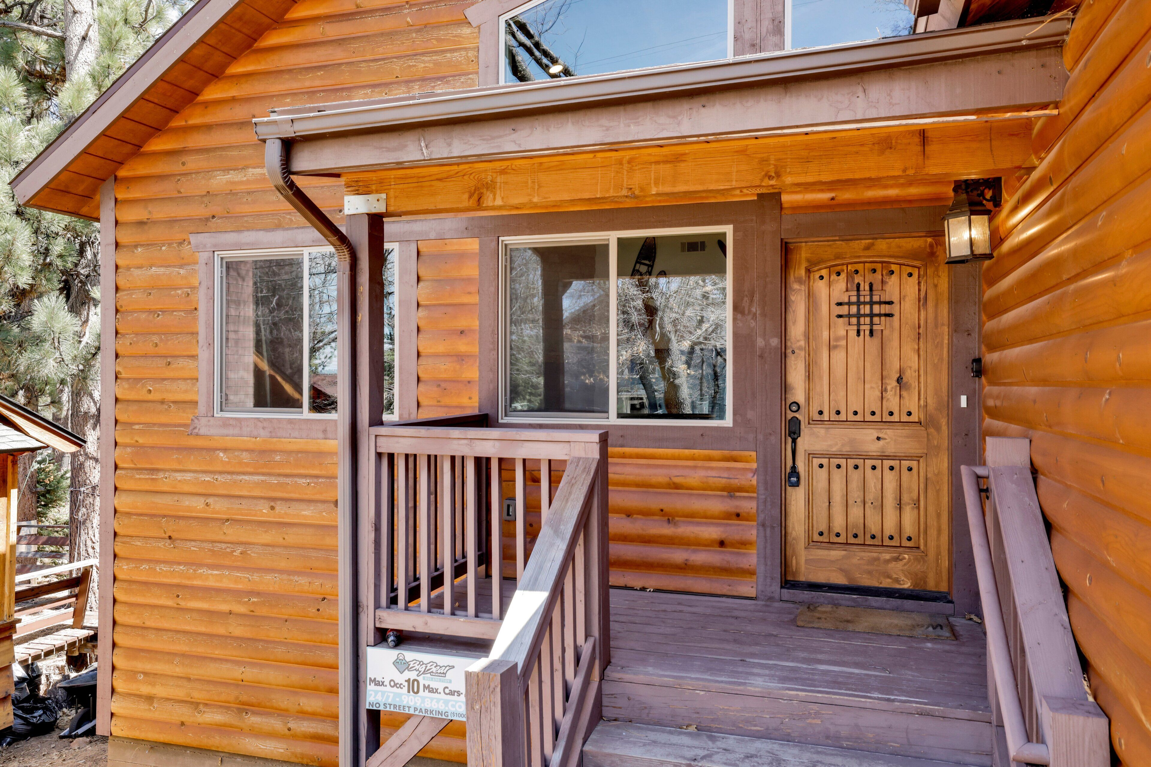 A wooden cabin with a porch, a double door, and a window.