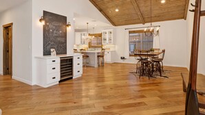 A spacious kitchen with wooden flooring, white cabinetry, and a large island. - Alpine Chalet #1840 (Big Bear Lake)