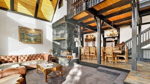 Ein großzügiger Wohnbereich mit Kamin, Ledersofa und Holzmöbeln.