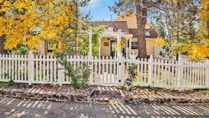 A house with a white picket fence, surrounded by trees with yellow leaves. - THE Winding Lane House EST 1932 #2360 (Big Bear City)