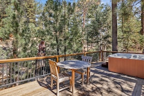 A wooden deck with a hot tub, a wooden chair, and a bear statue. - Top Notch Lodge#2056 (Big Bear Lake)