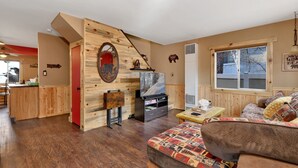 A cozy living room with a fireplace, a television, and a sofa. - Emma's Cottage#2267 (Big Bear City)