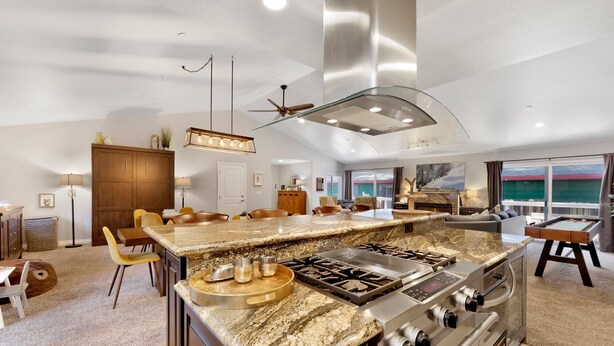 Una cucina moderna con una grande isola, elettrodomestici in acciaio inossidabile e vista all'esterno.