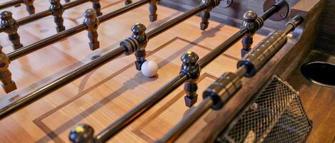 A foosball table with a wooden surface and metal rods.