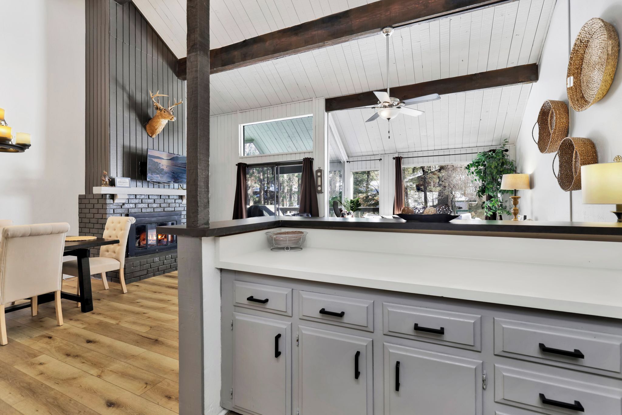 Una cocina moderna con una isla grande, gabinetes grises y una cabeza de venado decorativa.