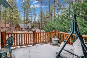 A wooden deck with a railing, a bench, and a chair. - Flitterbick Lodge #2246 (Fawnskin)