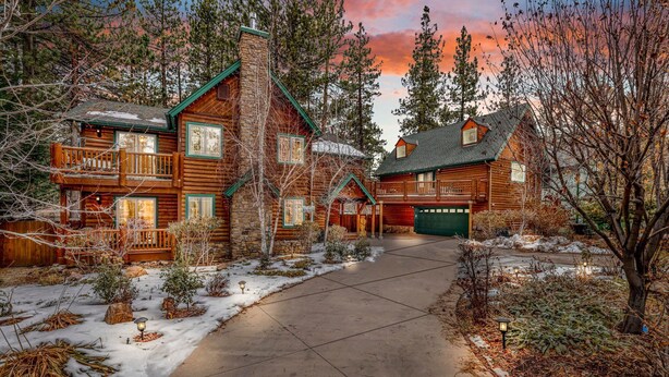A log cabin with a stone chimney, a covered porch, and a garage. - Flitterbick Lodge #2246 (Fawnskin)