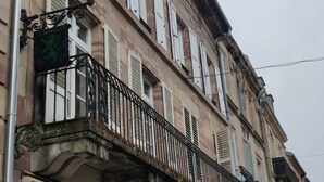 Een gebouw met balkon, een bord dat een hotel aangeeft en een straatlamp.