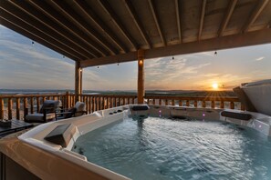 A hot tub with a wooden deck and lounge chairs, overlooking a scenic sunset view. - Luxury Lakeview, Hot Tub, Pickleball, Zero Stairs! (Branson)