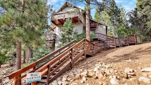 A wooden staircase leading to a cabin with a sign indicating parking restrictions.