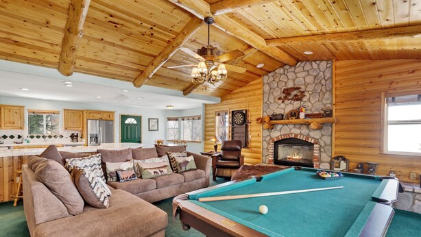 A cozy log cabin interior with a pool table, a fireplace, and a dining area. - Alameda Landing #2345 (Big Bear City)