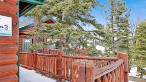 A wooden cabin with a wooden deck and a sign indicating a price of $1000. - Alameda Landing #2345 (Big Bear City)
