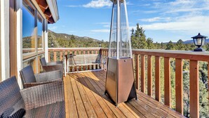 A wooden deck with wicker chairs and a metal grill, overlooking a mountainous landscape. - THE Octagon #2394 (Big Bear City)
