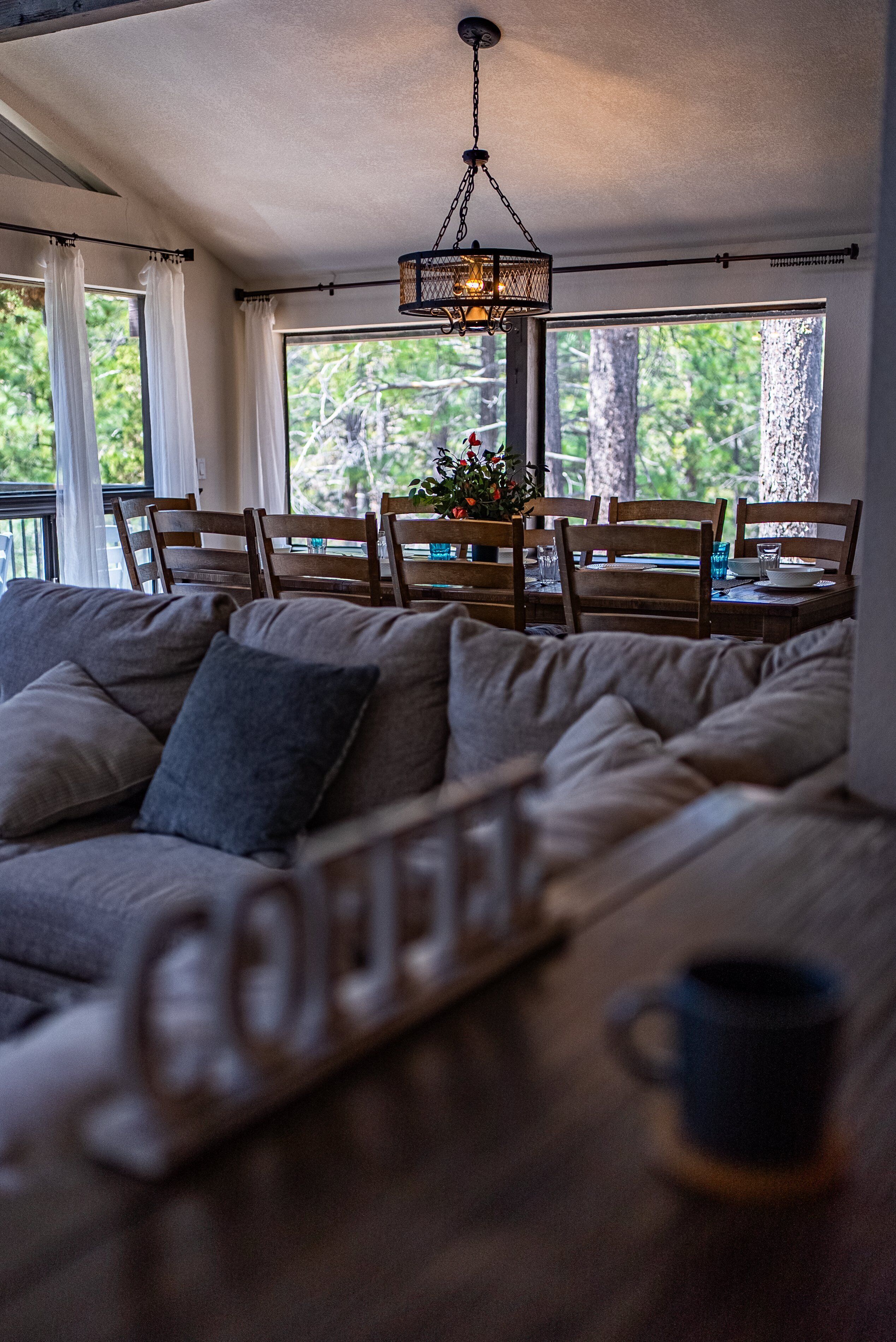 A cozy living room with a sofa, a coffee table, and a dining area with chairs and a table.