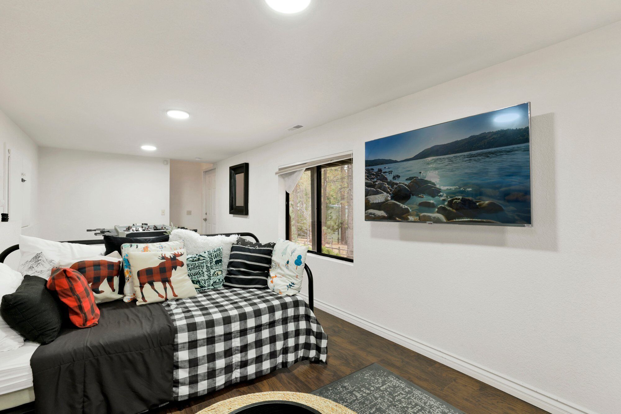 Un salón acogedor con un sofá a cuadros, una chimenea y un ventanal con vistas panorámicas.