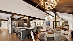 A spacious kitchen with dark wood cabinets, stainless steel appliances, and a large island. - Soaring Pines #2193 (Big Bear Lake)