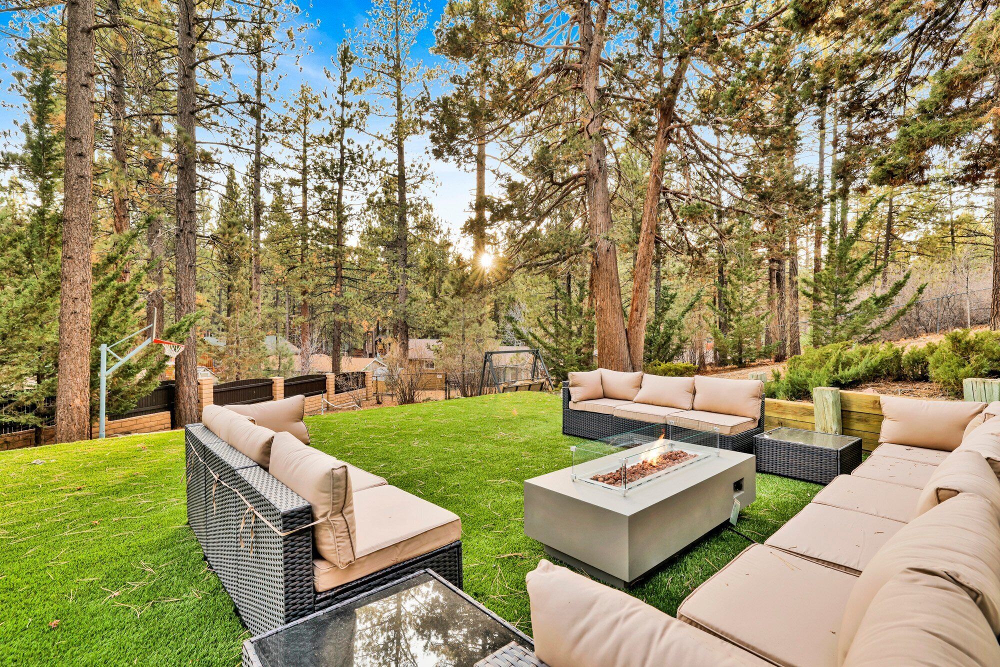 An outdoor patio area with a sectional sofa, a coffee table, and a fire pit.