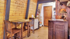 Un intérieur en bois comprenant un coin repas, une cuisine et un plafond en bois.