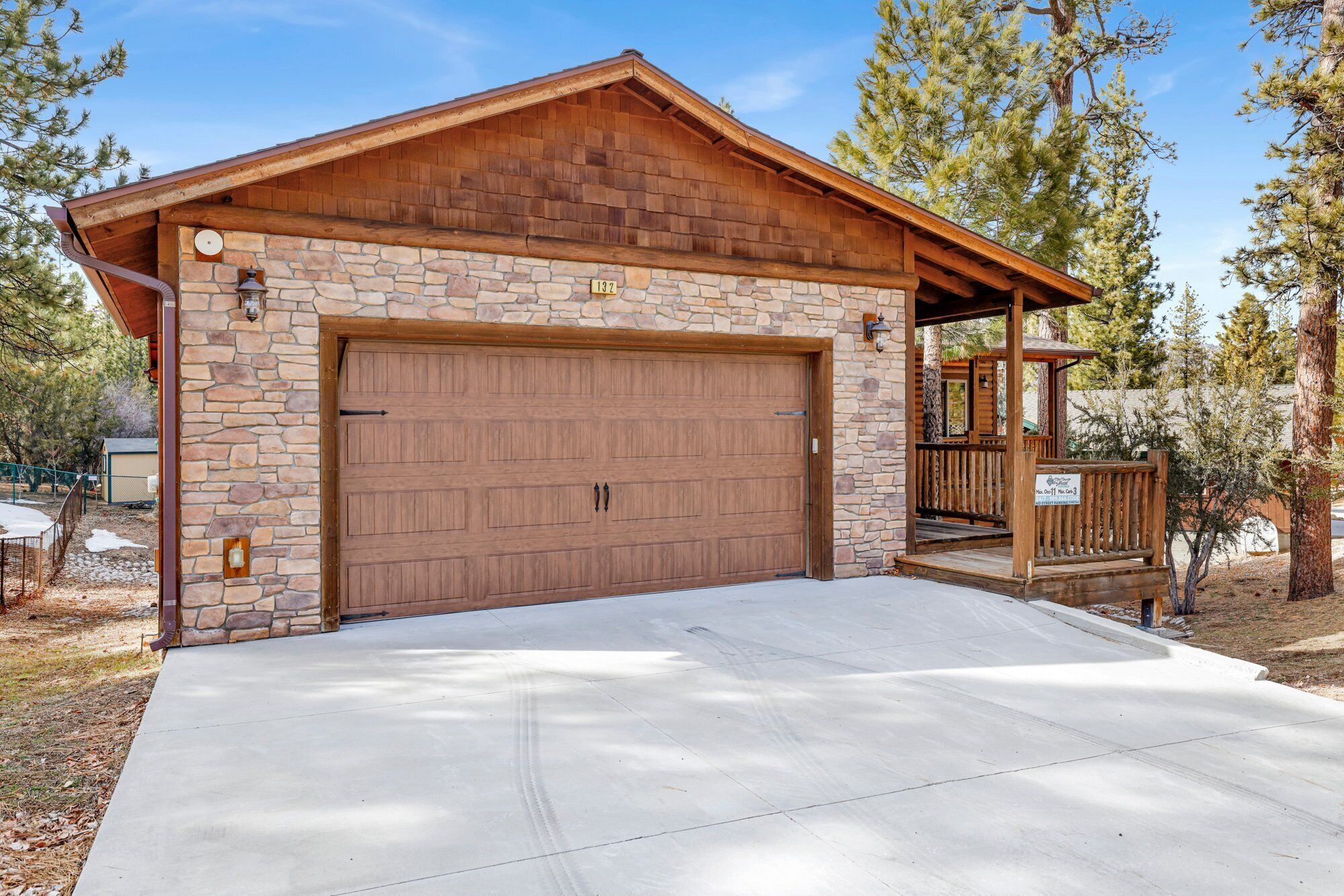 A stone and wood garage with a large door, a small porch, and a sign indicating a restaurant.