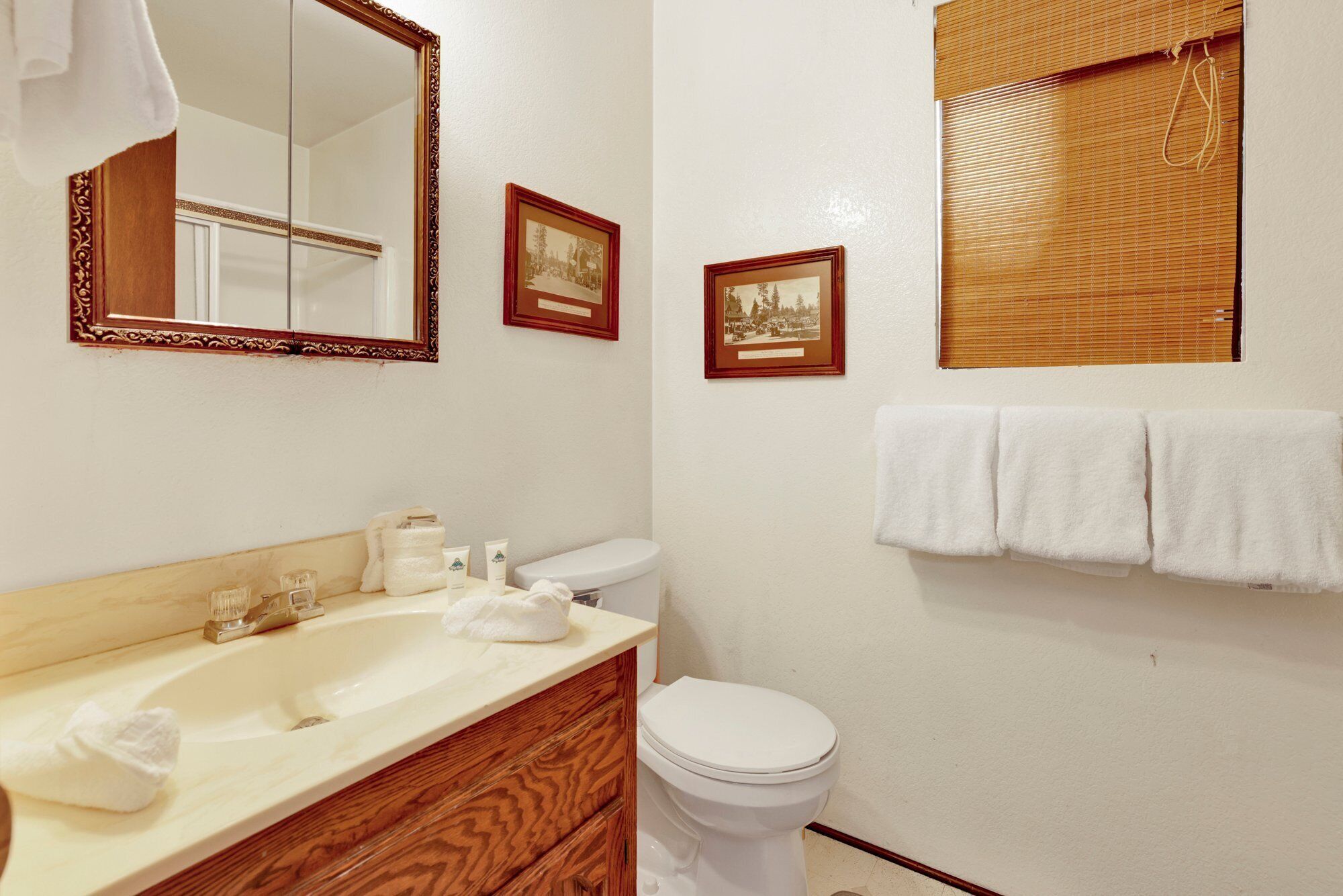 Une salle de bain équipée d’un lavabo, d’un miroir, de toilettes et d’un porte-serviettes.