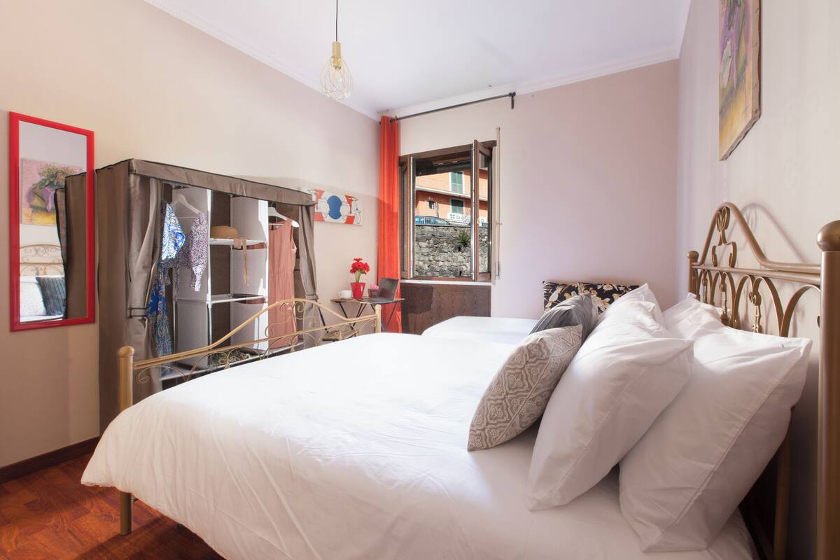 Una camera da letto con un letto, un armadio, una scrivania e una finestra.
