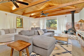 Relax in a spacious living room with a comfortable sectional sofa, coffee table, and wood-burning stove.