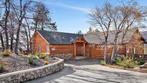 Une cabane en bois avec des fondations en pierre, un mur de soutènement en pierre et une allée pavée.