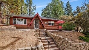 A log cabin with a stone staircase leading to a porch with outdoor seating. - Moulin Rouge #2055 (Big Bear Lake)