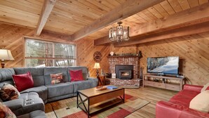 A cozy living room with a fireplace, a television, and a sofa. - Alpine Adventure #2166 (Big Bear City)