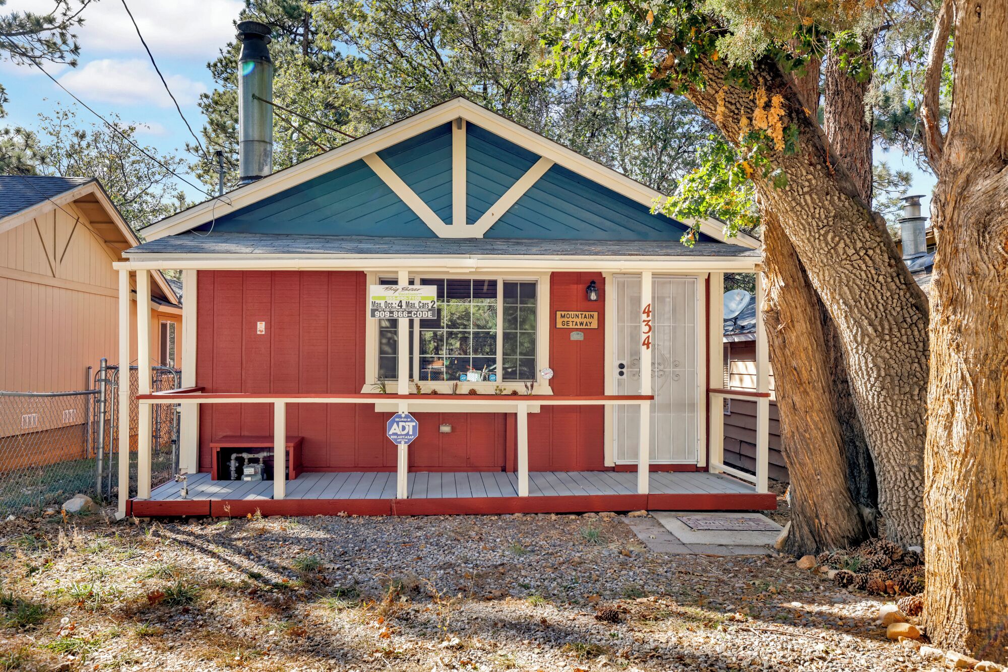 A small, single-story building with a red facade, a blue roof, and a sign indicating it is a mountain getaway.
