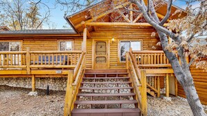 A log cabin with a stone foundation, wooden steps leading to a porch, and a number '1346' on the front. - Crescenta Pines LOG Cabin #2346 (Big Bear City)