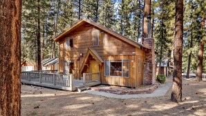 A log cabin with a porch, surrounded by tall pine trees. - Paradise IN Cedar #2095 (Big Bear Lake)