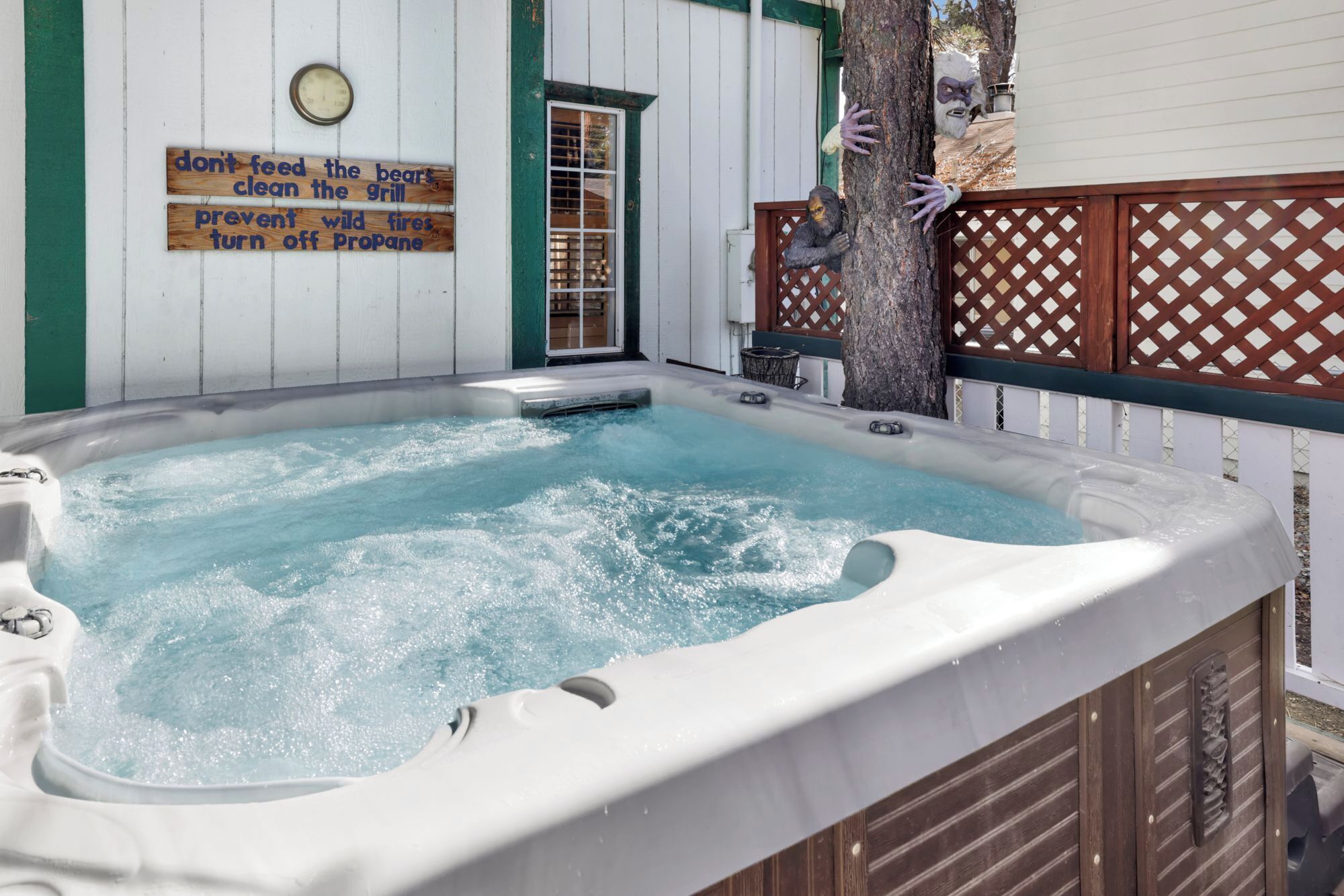 A hot tub with a wooden deck and a sign with safety instructions.