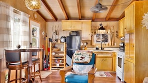 A wooden interior with a kitchen area, including a refrigerator, microwave, and wooden cabinets. - SKI View Chalet #2215 (Big Bear Lake)