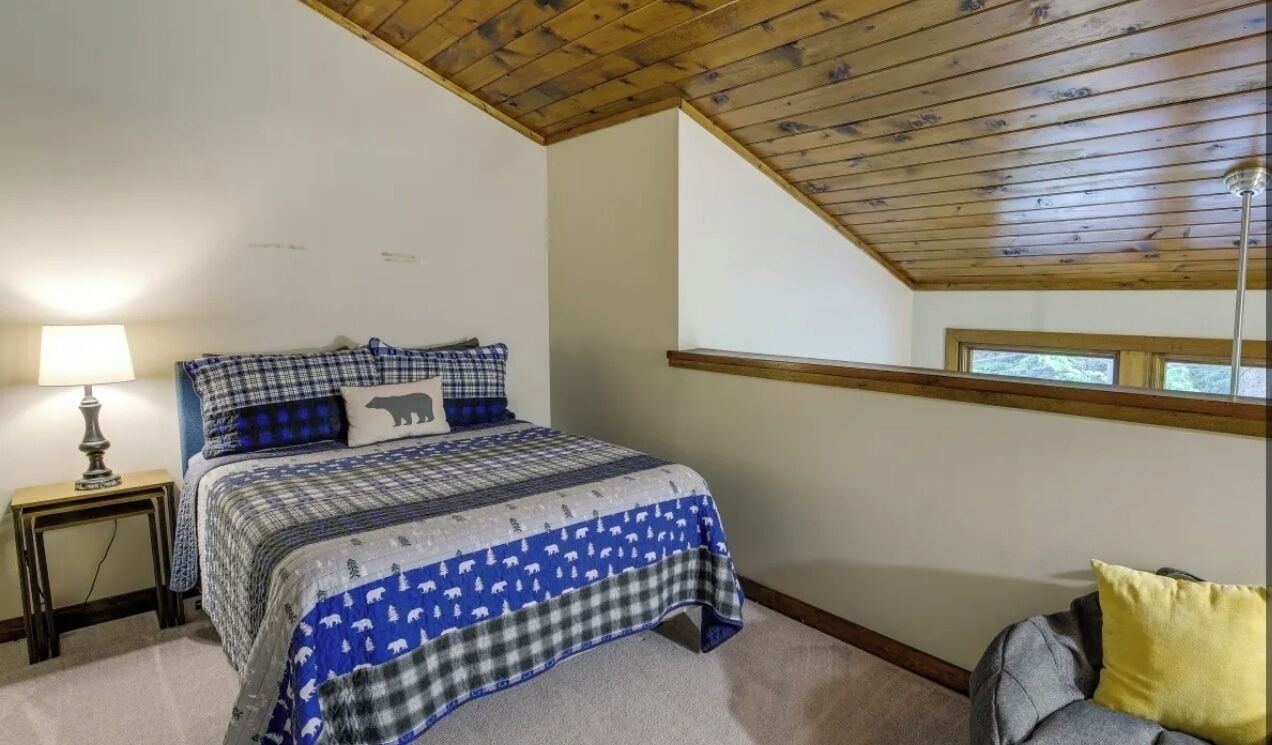 Una camera da letto con un letto, un comodino, una lampada e una finestra.