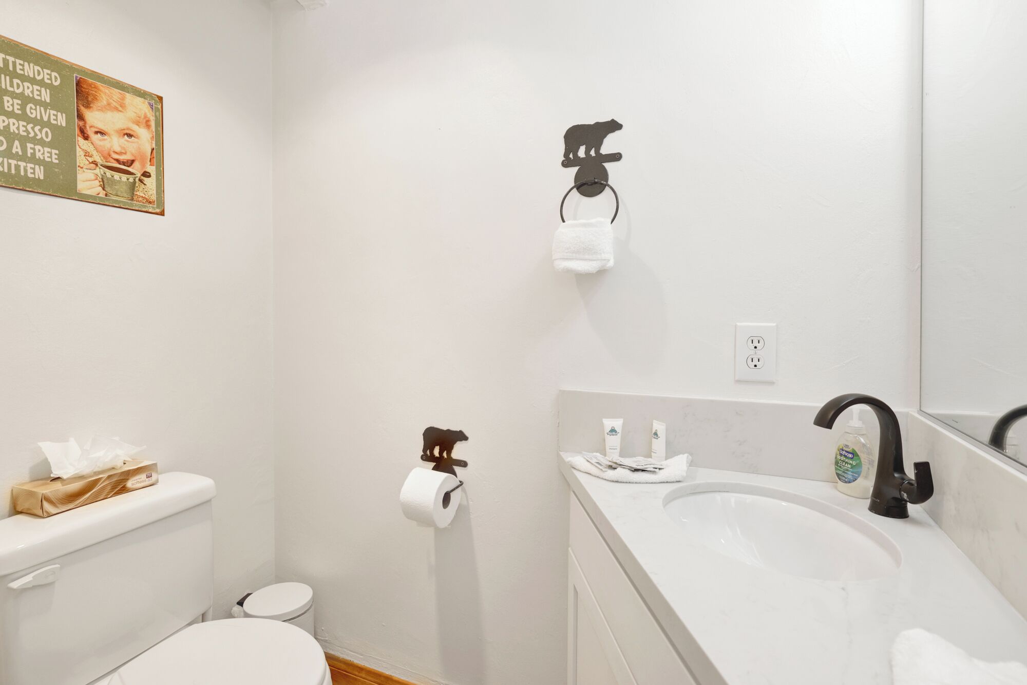 A bathroom with a toilet, sink, and towel rack.