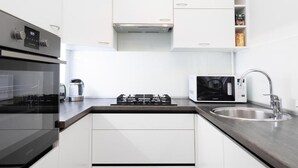 A modern kitchen with a built-in oven, microwave, gas stove, and stainless steel sink.
