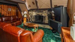 A cozy living room with leather sofas, a stone fireplace, and a television. - Makin' Memories AT Summit #1683 (Big Bear Lake)