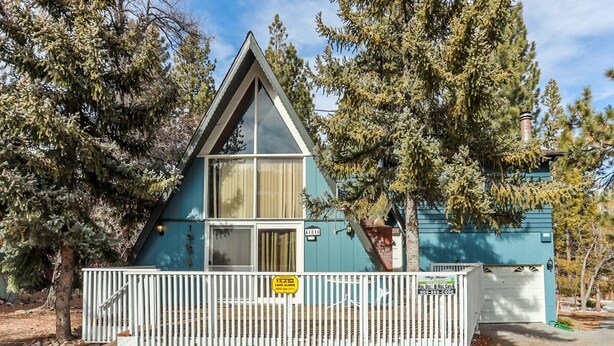 A small, triangular cabin with a white picket fence, surrounded by trees. - Makin' Memories AT Summit #1683 (Big Bear Lake)