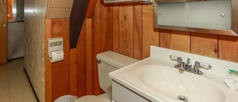A bathroom with a toilet, sink, and towel rack.