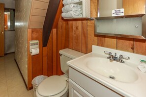Une salle de bain équipée de toilettes, d’un lavabo et d’un porte-serviettes.