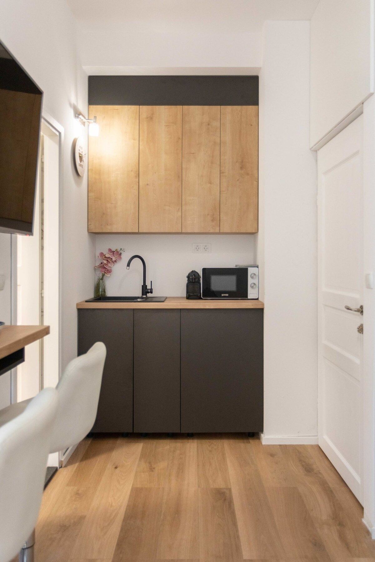 A compact kitchen with wooden cabinets, a microwave, and a sink.