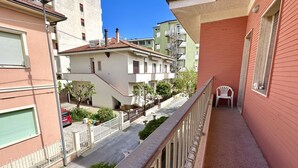 Un edificio residencial con balcones, vista a la calle y edificios vecinos.