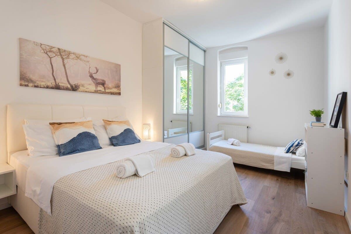 Une chambre à coucher avec un lit, un banc et un miroir.