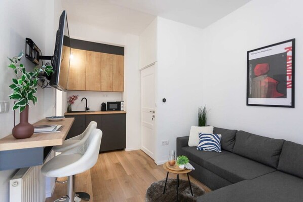 A compact living space with a kitchenette, a dining area, and a seating area.