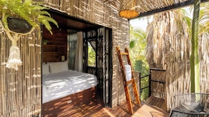 Une terrasse en bois avec un lit, une chaise et une plante suspendue.