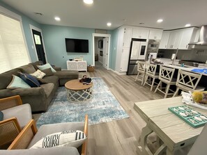 Una sala moderna con sofá, mesa de centro y comedor.