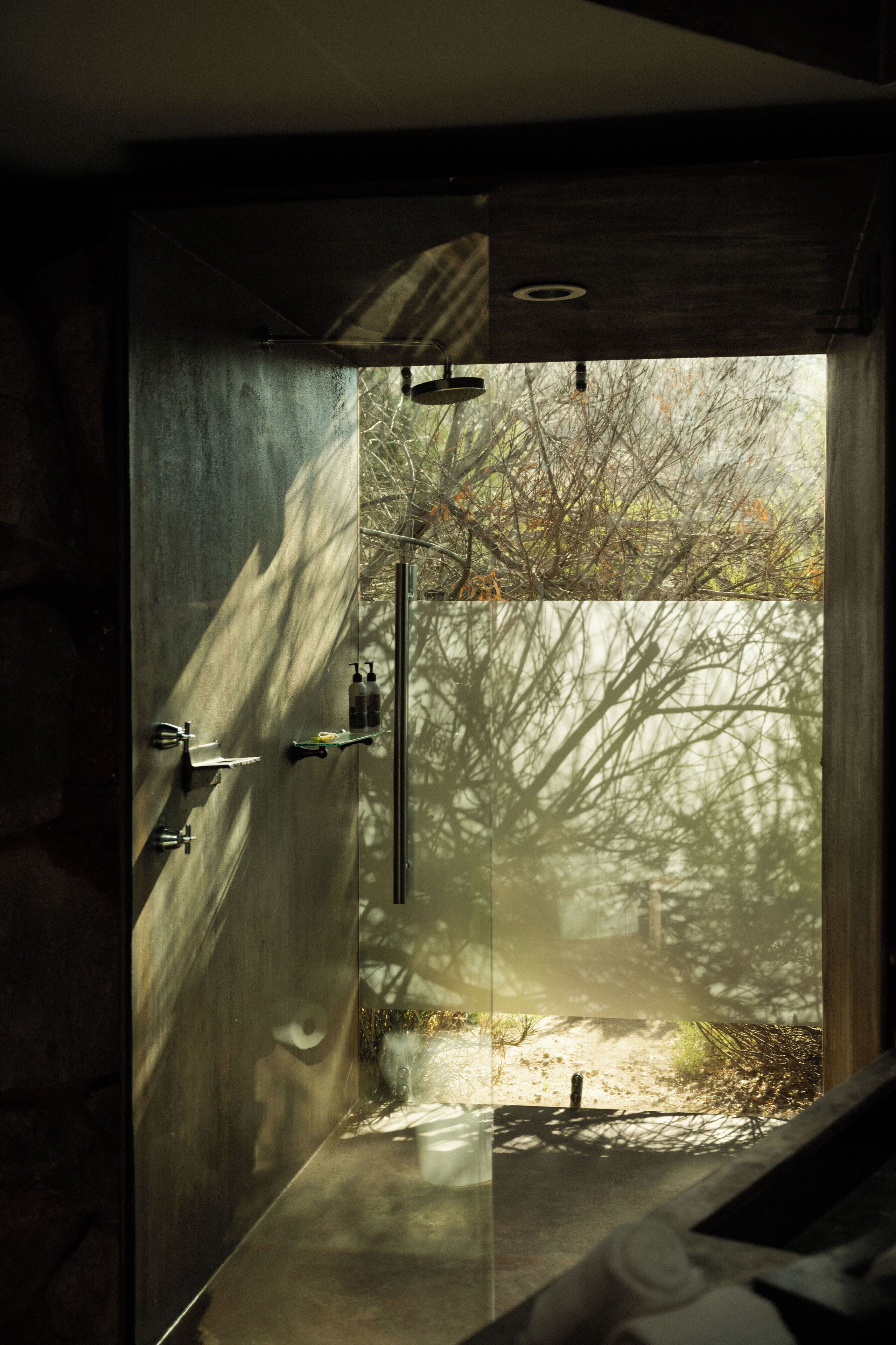 A modern bathroom with a glass shower enclosure, a visible showerhead, and a towel rack.